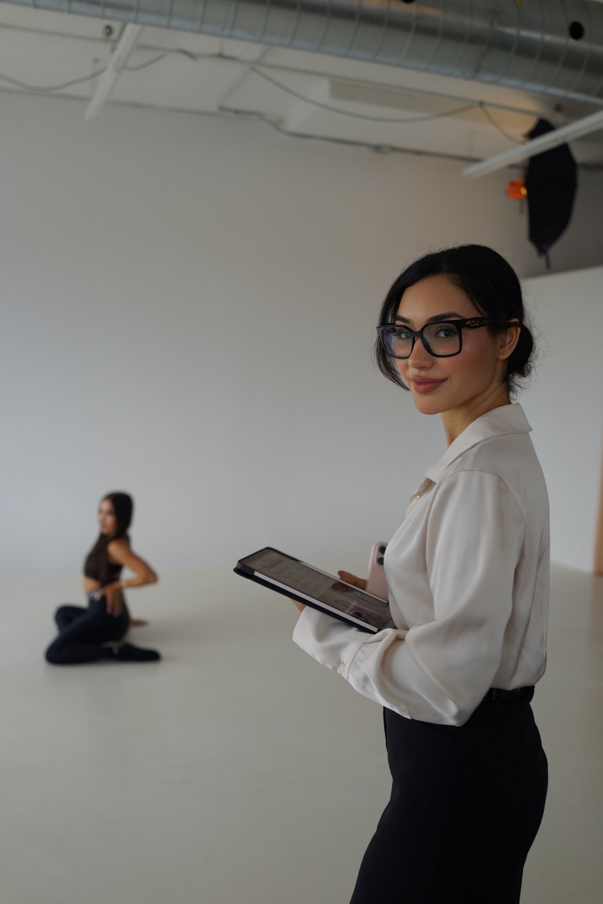 Helia Homam directing a photoshoot with a model in the background